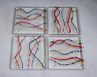 Fused glass coasters. 'Serpentine - Fire'  Black, red and yellow on a clear base. Squiggly coasters. Choose 2 or 4. Can be customized.