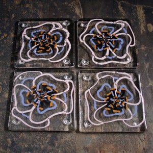 Kiln Fused glass coasters. 'Viola' Hand painted large pink and mauve flowers with black golden tipped stamens on a clear glass base. image 1