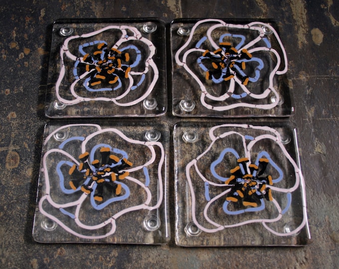 Kiln Fused glass coasters. 'Viola'  Hand painted large pink and mauve flowers with black golden tipped stamens on a clear glass base.