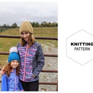 May include: Two people wearing knitted hats, one in a blue and white hat with a white pom pom and the other in a beige hat. They are standing in front of a rusty metal gate.