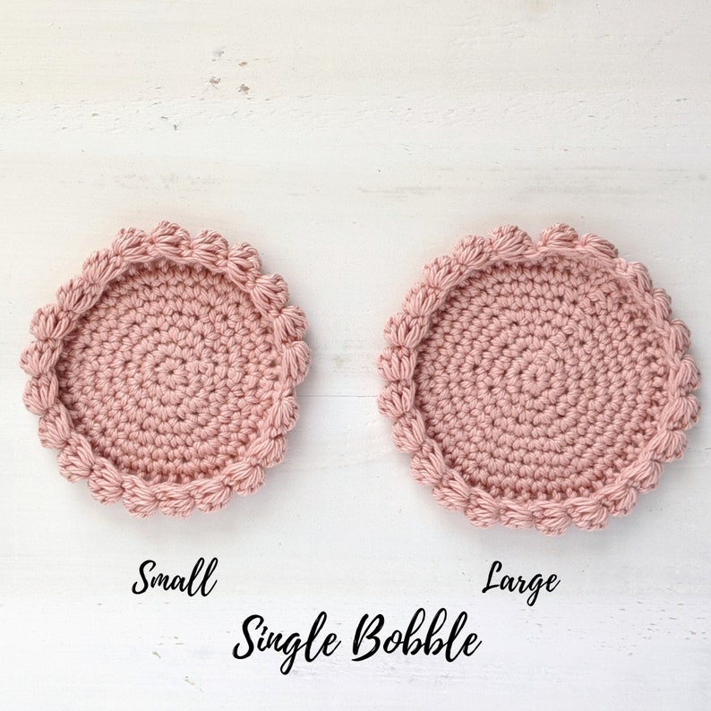Puede incluir: Dos posavasos de ganchillo, uno peque&ntilde;o y otro grande, con un borde de punto bobble simple. Los posavasos son de color rosa claro y est&aacute;n hechos con un punto de ganchillo simple.