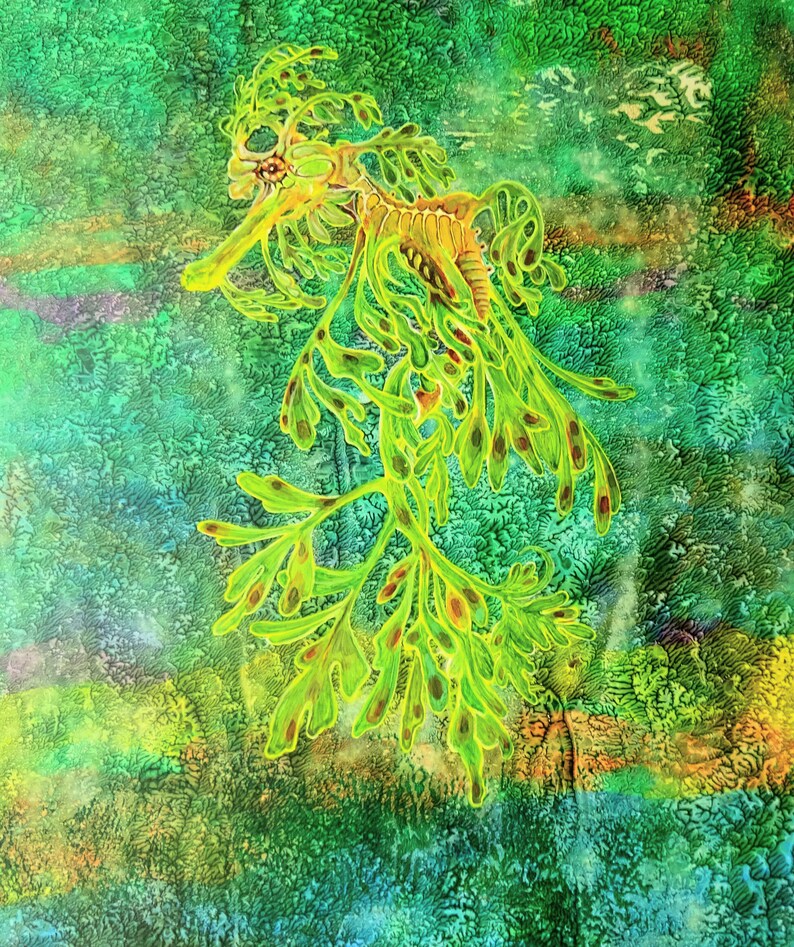 May include: A detailed illustration of a leafy seadragon, set against a textured backdrop of greens and blues. The seadragon is depicted in bright green with brown markings, its body adorned with leaf-like appendages. The artwork has a watercolour effect.