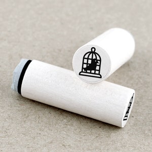 Mini stempel vogel in een kooi