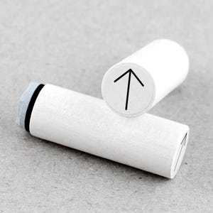 May include: Two white cylindrical wooden stampers with black ink pads. One stamper has an arrow pointing upwards, the other has an arrow pointing downwards.