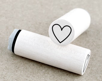 May include: Two white wooden stampers with black ink pads. The stampers have a heart design on the top.