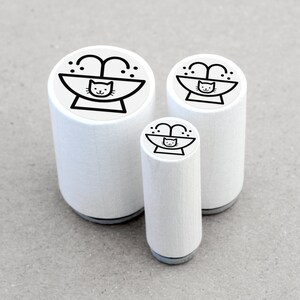 May include: Three white rubber stamps with a black outline of a cat in a bath with water spraying from the tap. The stamps are different sizes.