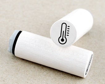 May include: Two white wooden stampers with black ink pads. The stamper on top has a black line drawing of a thermometer on the top. The stamper on the bottom has a black line drawing of a thermometer on the side.