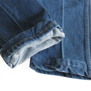 May include: A pair of blue denim jeans with the cuffs turned up. The jeans are made from a soft, comfortable fabric and have a classic look.