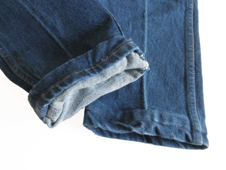 May include: A pair of blue denim jeans with the cuffs turned up. The jeans are made from a soft, comfortable fabric and have a classic look.