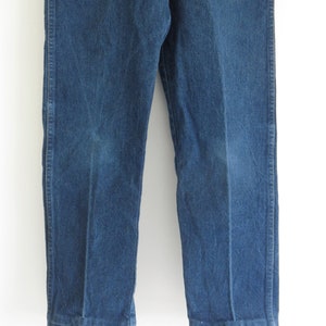 May include: A pair of blue denim jeans with a straight leg fit. The jeans have a classic look and are made from a durable material.