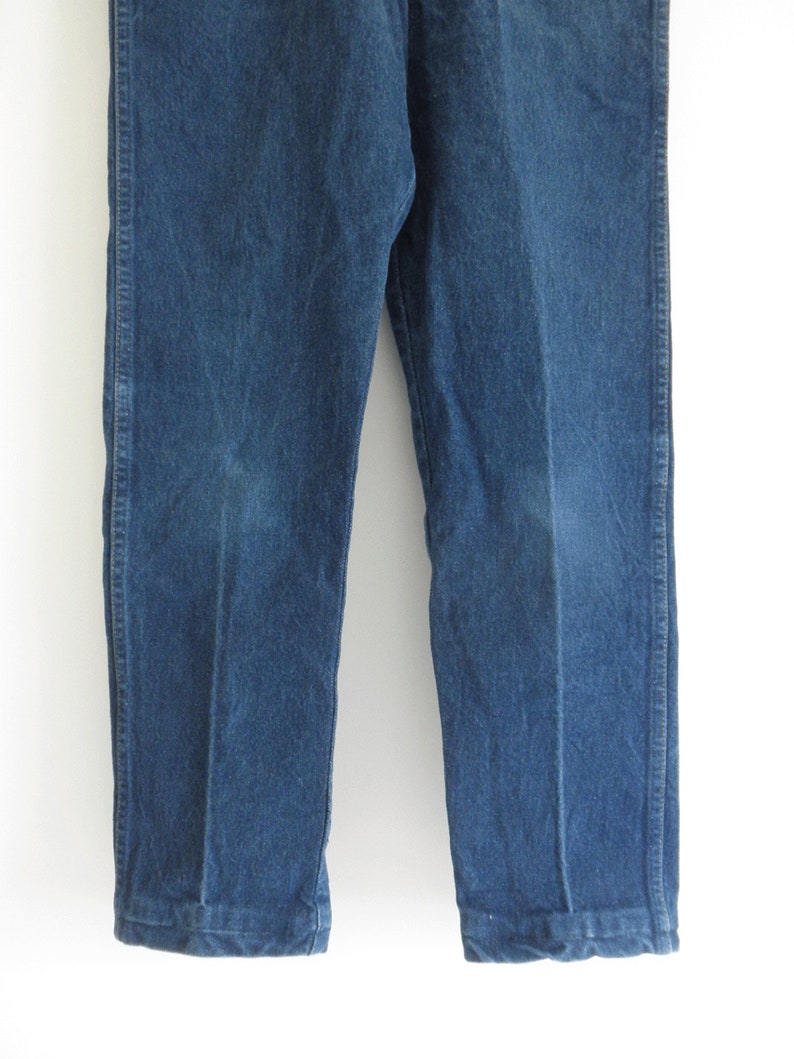 May include: A pair of blue denim jeans with a straight leg fit. The jeans have a classic look and are made from a durable material.
