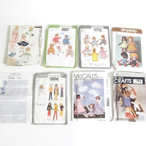 May include: A collection of eight vintage sewing patterns for dolls and children's clothing. The patterns are from Simplicity and McCall's Crafts and feature various designs, including dresses, shirts, and pants.