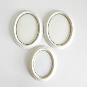 May include: Three white oval picture frames with gold trim. The frames are arranged in a triangular pattern.