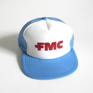 May include: A blue and white trucker hat with a red "FMC" logo on the front.