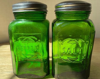 Salières et poivrières en verre vert gaufré. La grande paire de shakers est une reproduction de bouteilles Hazel Atlas de l'époque de la dépression des années 30.