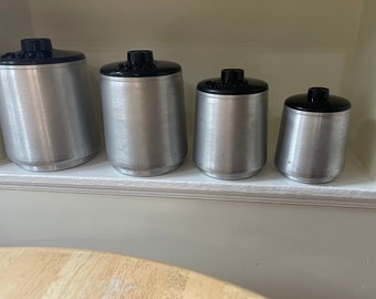 Vintage Kitchen Canisters. Set of 4 Kormex Spun Aluminum canisters with black lids labeled for Flour, Sugar, Coffee and Tea. 1950s Style.