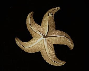 Broche vintage de estrella de mar. Joya Giovanni coleccionable en tono dorado de la década de 1960. Criatura marina grande y texturizada con patas onduladas. 5 x 5 cm.