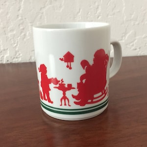 Avon Christmas Mug with Santa and his Elves. Vintage Collectible from 1984. Red silhouettes on White background & Green stripe. Perfect.