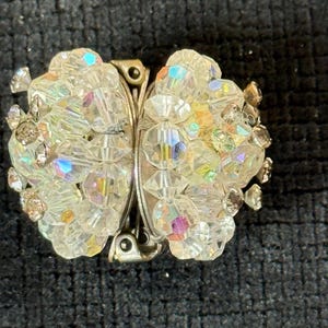 Puede incluir: Broche vintage con forma de mariposa. El broche est&aacute; hecho de cuentas de cristal transparente e iridiscente y metal plateado. Los cristales reflejan un arco&iacute;ris de colores. Un accesorio cl&aacute;sico.