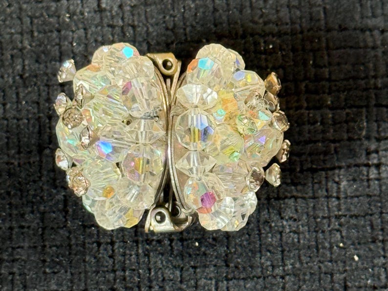 Puede incluir: Broche vintage con forma de mariposa. El broche est&aacute; hecho de cuentas de cristal transparente e iridiscente y metal plateado. Los cristales reflejan un arco&iacute;ris de colores. Un accesorio cl&aacute;sico.