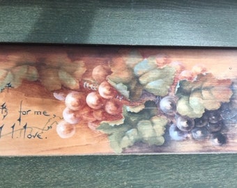 May include: A wooden sign with a painted image of two bunches of grapes. The sign has the words "eats for me" and "I love" written on it.