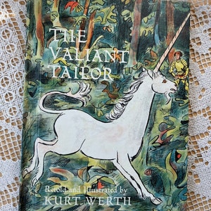 Può includere: La copertina di un libro per bambini intitolato "Il Sarto Valiente" illustrato con un unicorno bianco che corre in una foresta verde e blu. Il libro è di Kurt Werth.