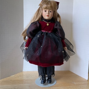 Vintage Viktorianische Mädchen-Puppe. Sie ist 17-1 / 2 &quot;groß und hat Porzellankopf, -arme und -beine und lange blonde Haare. Ausstellungsständer inklusive.