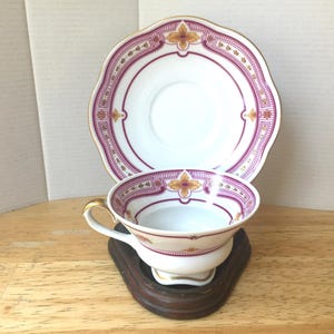 Antique Porcelain Cup & Saucer. White with red borders and tiny flowers, gold trim. Beautiful and unique. Perfect Condition. Beautiful set!