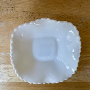 May include: White milk glass square dish with a scalloped edge and a smaller square indentation in the center.