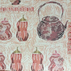 Puede incluir: Un patr&oacute;n repetido de ilustraciones estilizadas de teteras y calabazas marrones y rosas sobre un fondo crema. El patr&oacute;n recuerda a una xilograf&iacute;a japonesa.