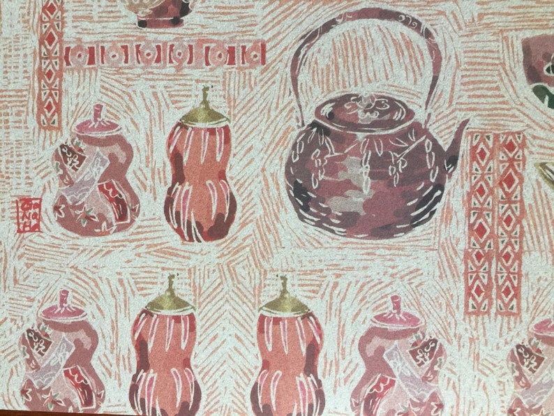 Puede incluir: Un patr&oacute;n repetido de ilustraciones estilizadas de teteras y calabazas marrones y rosas sobre un fondo crema. El patr&oacute;n recuerda a una xilograf&iacute;a japonesa.