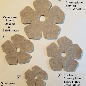 May include: Four felt flower-shaped placemats in different sizes: 5 inches, 7 inches, 8 inches, and 10 inches. The placemats are beige and have a center hole. The placemats are labeled with their size and the type of dishes they are intended for.