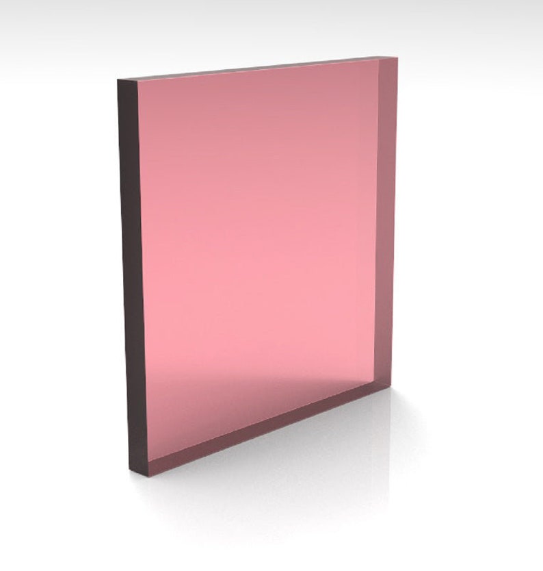 May include: A rectangular, translucent, pink-colored object with dark brown edges. The object is standing upright and appears to be made of glass or a similar material. The surface reflects light, creating a glossy appearance.