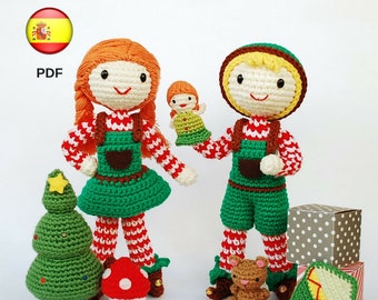 May include: Crocheted Christmas elf dolls, a girl and a boy, with red and white striped outfits, green trousers, and brown boots. The girl is holding a small crocheted doll. The boy is holding a small crocheted bear. There is a crocheted Christmas tree, a mushroom, and a house in the foreground.