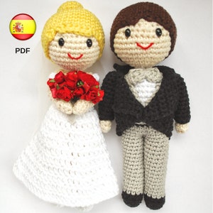 Puede incluir: Muñecas de crochet de novia y novio. La novia lleva un vestido blanco y sostiene un ramo de rosas rojas. El novio lleva un traje negro con camisa blanca y pajarita.