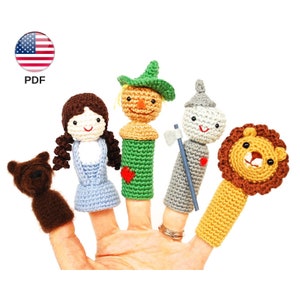 Puede incluir: Un conjunto de cinco marionetas de dedo con personajes de El Mago de Oz. Las marionetas están hechas a crochet e incluyen a Dorothy, el Espantapájaros, el Hombre de Hojalata, el León Cobarde y Toto el perro.
