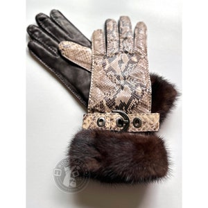 May include: A pair of brown leather gloves with a snakeskin pattern on the back of the hand. The gloves have a fur cuff and a buckle detail.
