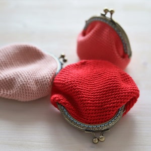 May include: Three crocheted coin purses in pink and red with metal clasps.