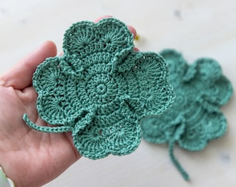 May include: A crocheted green four-leaf clover with a textured design.