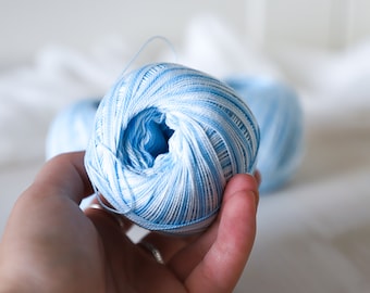 May include: A ball of light blue and white yarn.