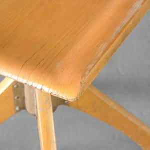 Op de afbeelding: Een houten stoel met een lichtbruine afwerking en een stervormige basis. De stoel heeft een eenvoudig ontwerp en is gemaakt van massief hout.