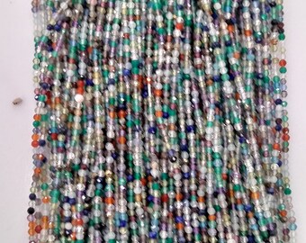 May include: A strand of multi-colored gemstone beads. The beads are small and round, and they are strung together on a clear thread. The beads are a mix of colors, including green, blue, red, orange, and white.