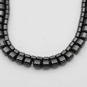 May include: A strand of black hematite beads, each bead is cylindrical and has a smooth, polished finish.