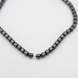 May include: A strand of black hematite beads, strung on a thin wire.