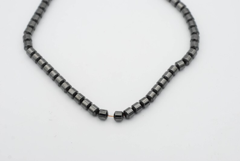 May include: A strand of black hematite beads, strung on a thin wire.
