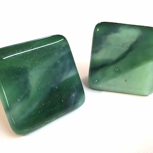 Puede incluir: Dos pomos de armario cuadrados de vidrio con un diseño de mármol verde y blanco.