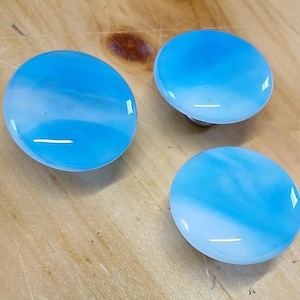 May include: Three blue and white glass knobs with a swirl pattern.