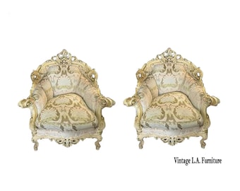 May include: Two antique armchairs with cream upholstery and gold-painted wooden frames. The chairs have intricate carvings and patterned fabric. The text "Vintage L.A. Furniture" is visible at the bottom right.