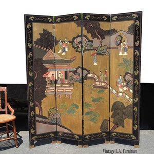 May include: A four-panel room divider screen with a black frame and gold background. The screen features a painted scene of a Chinese garden with people in traditional clothing.