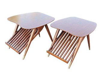 May include: Two mid-century modern end tables with slatted magazine racks. The tables are made of wood with a dark brown finish and have a unique, angled design.